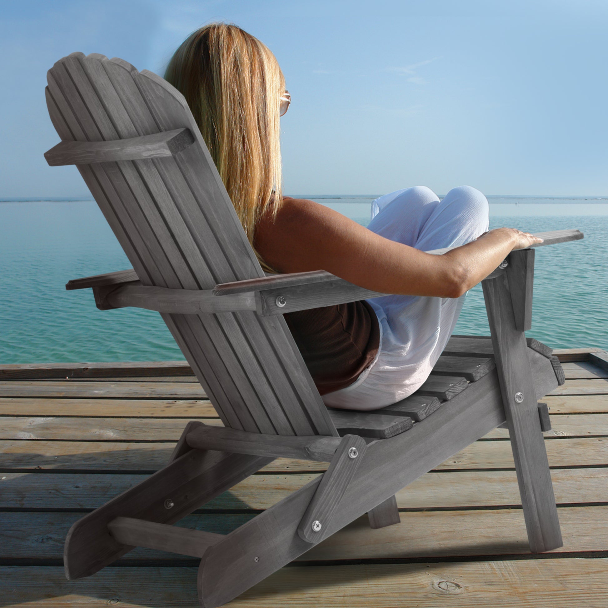 Woman Enjoying Comfortable Gray Wooden Adirondack Chair