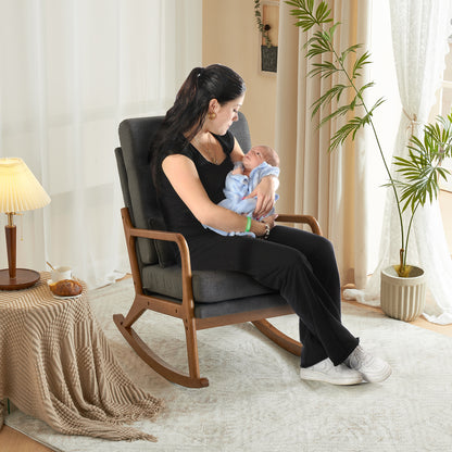 A lady holding a baby in the comfortable grey linen indoor rocking chair.