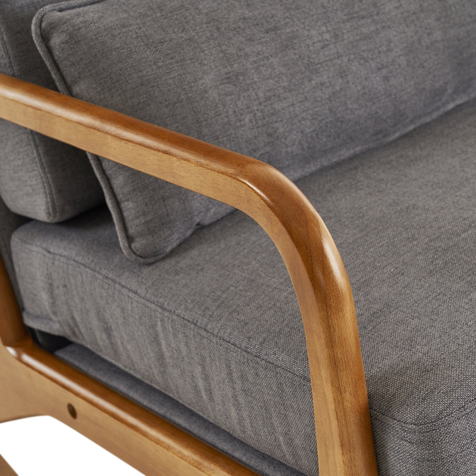 Close-up view of the wood armrest of the elegant grey linen indoor rocking chair.